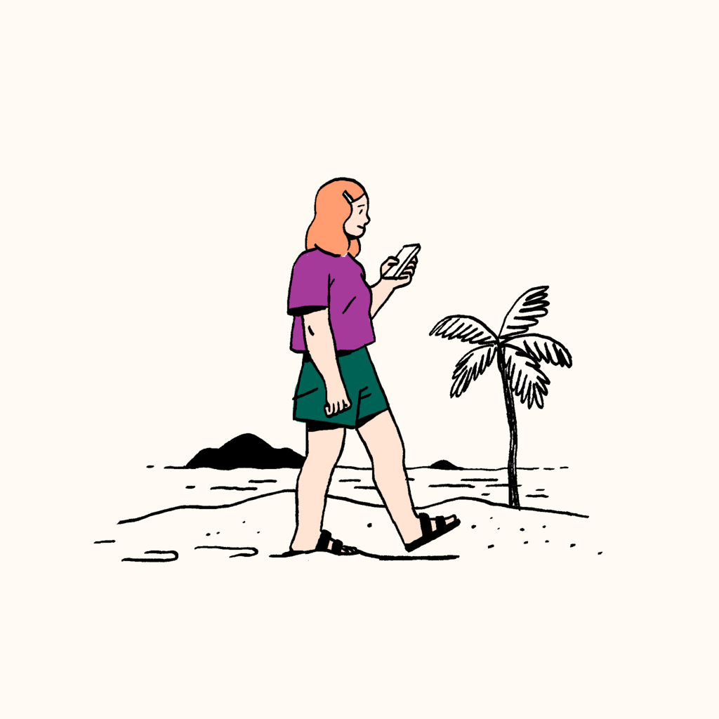 Woman looking at her phone on a beach