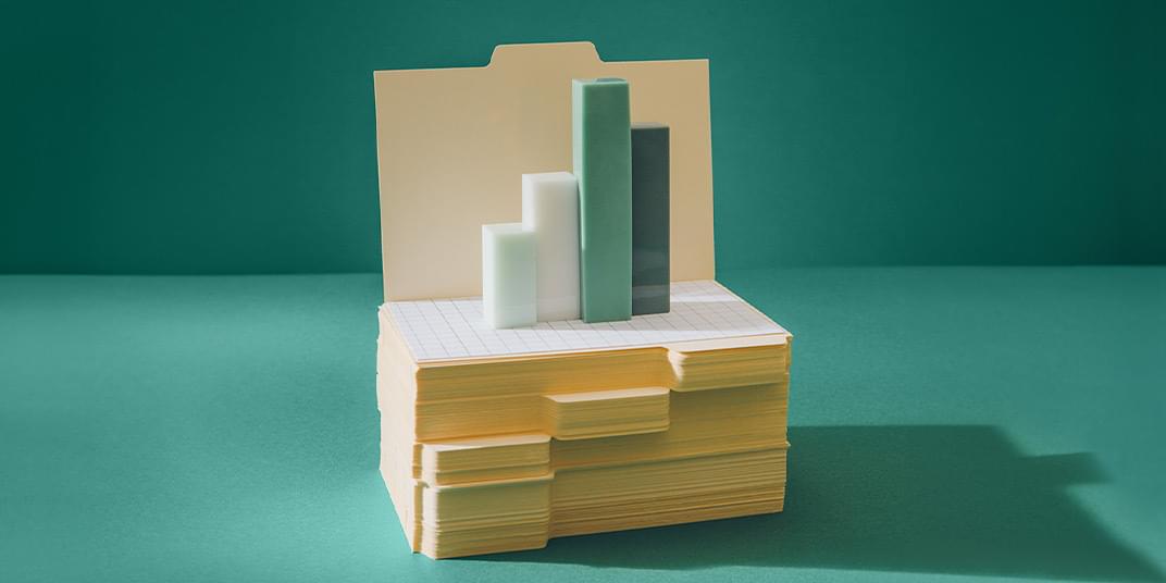 Four bars sit on top of a stack of folders, representing the concept of workforce forecasting.