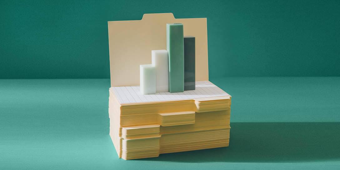 A stack of file folders serves as the base for four vertical bar graphs.