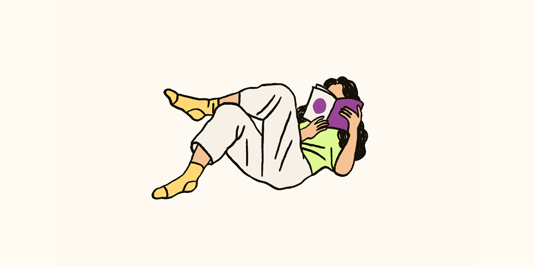 A woman lies on her back and reads about customer persona templates.