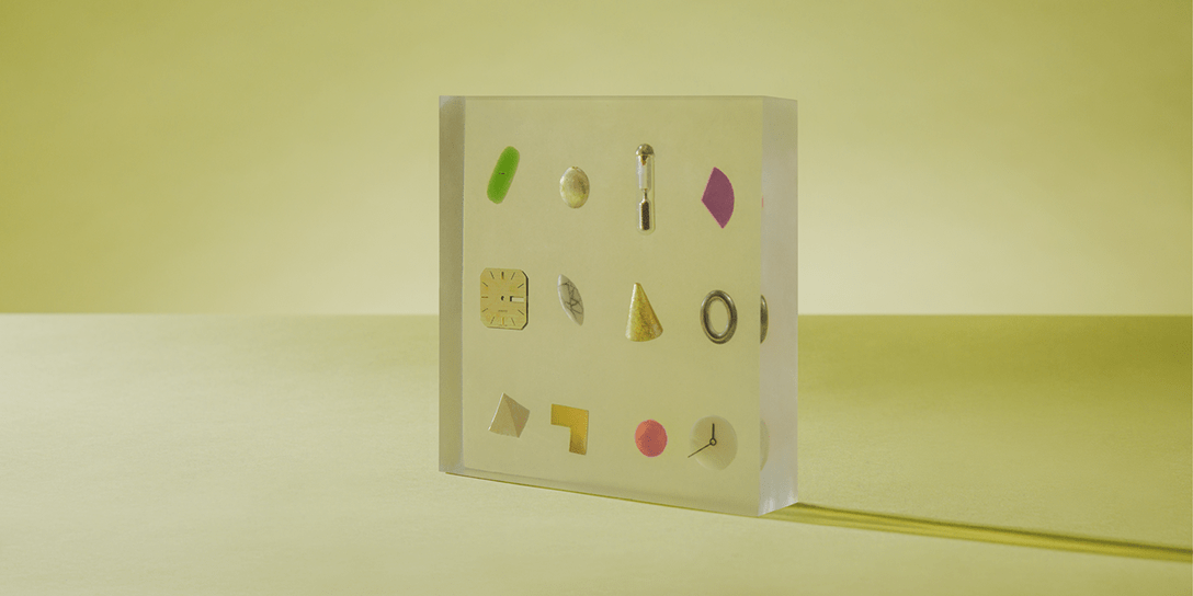 A clear, acrylic block has shapes suspended in its center.