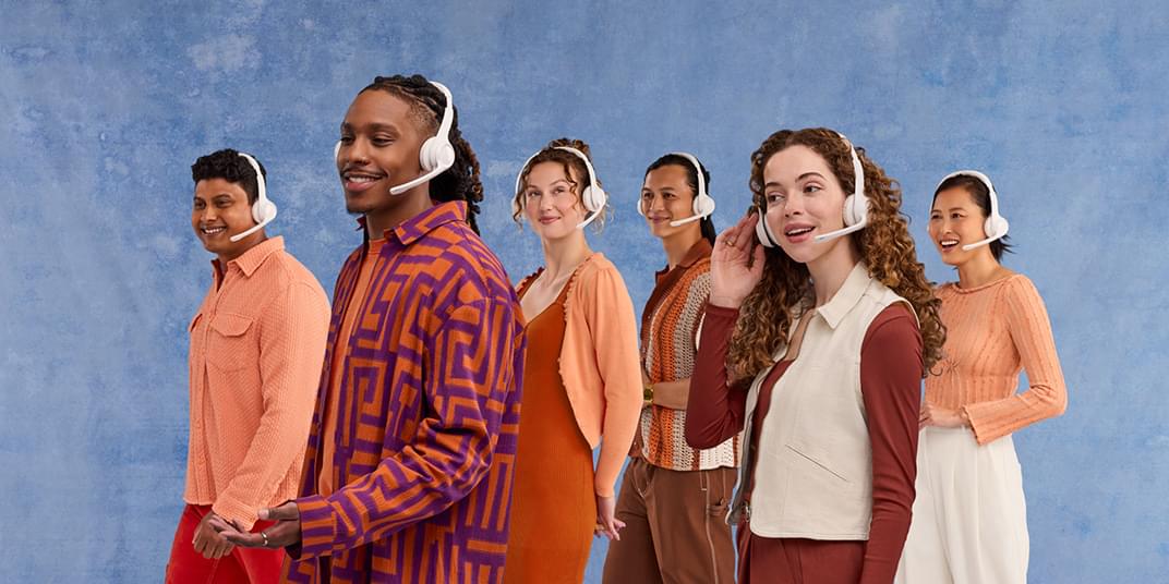  A group of people wearing headsets stand in front of a blue background