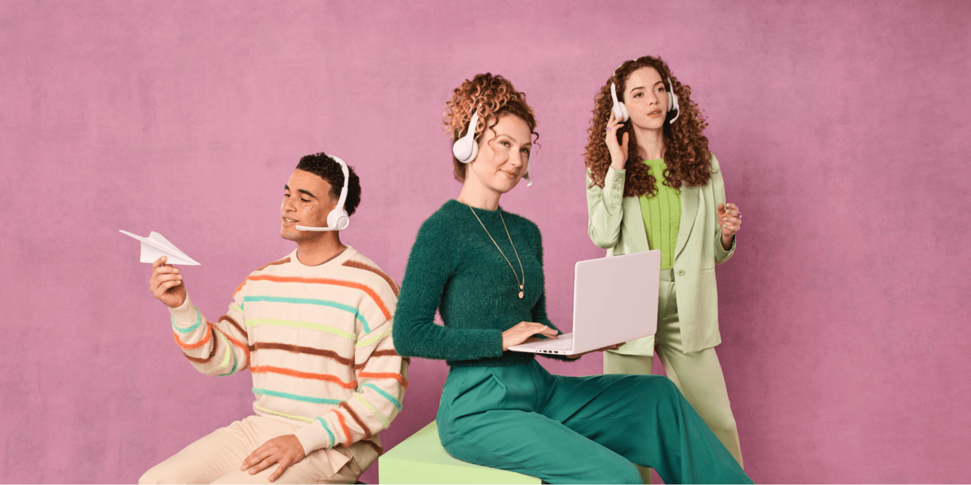 Three agents wearing headsets work at an IT service desk.