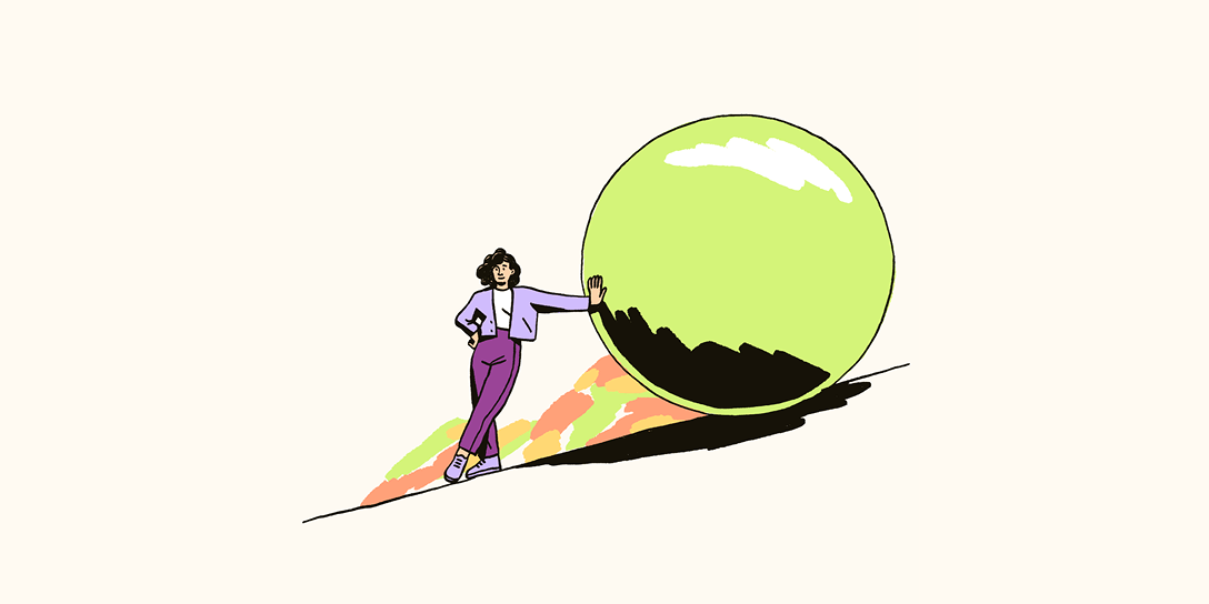 A person in a purple monochromatic outfit leans on a green ball as it sits on a hill.