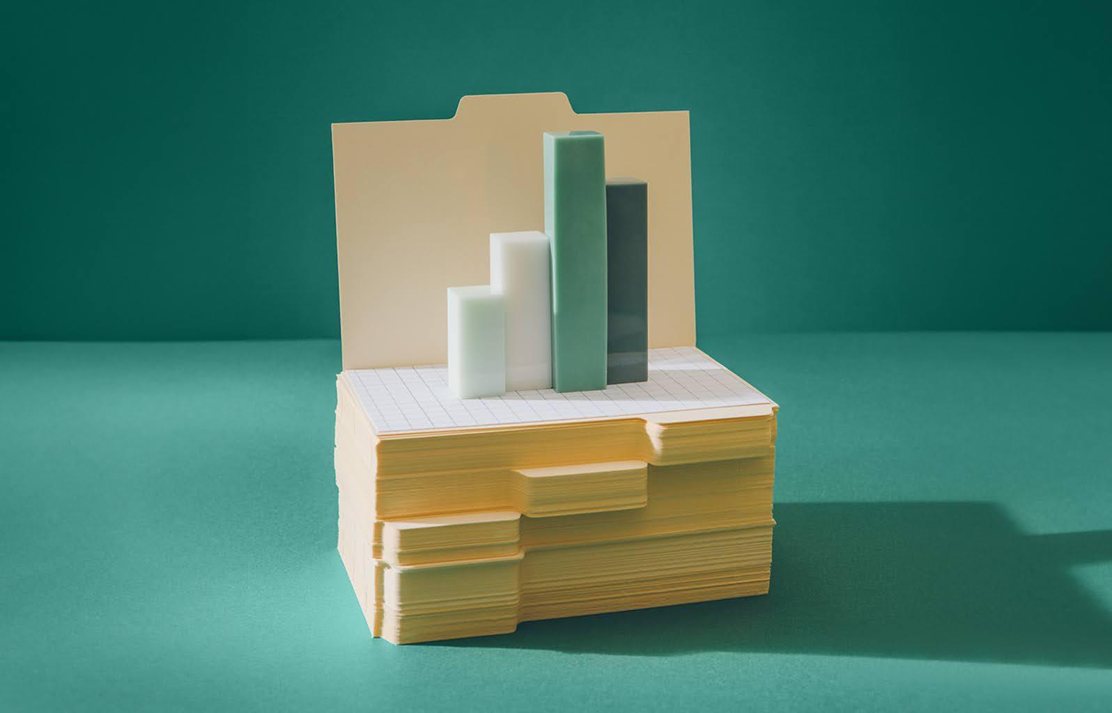 An image showcases a bar graph made up of four blocks on top of a stack of files.