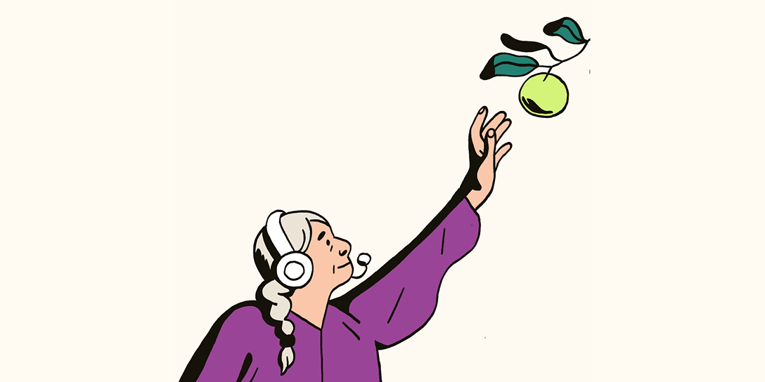 A woman with a headset on reaches for an apple on a branch.