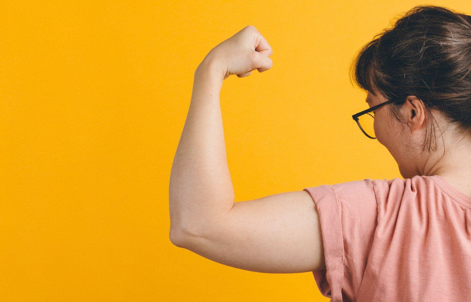 Vue de dos d’une femme fléchissant son biceps