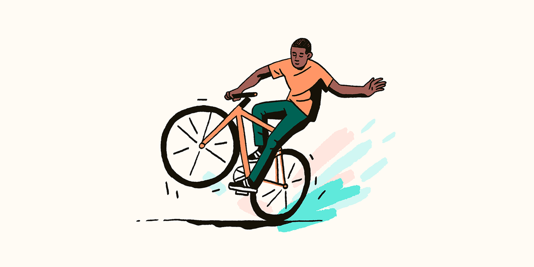 A man doing a wheelie on a bicycle