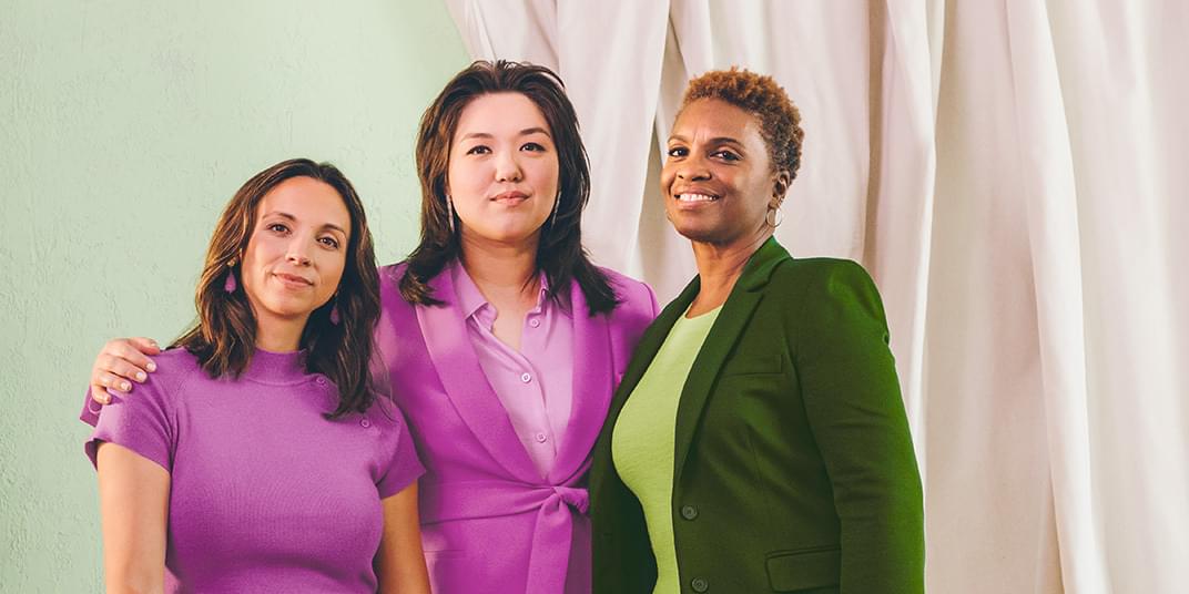 Three female HR managers pose for a photo.