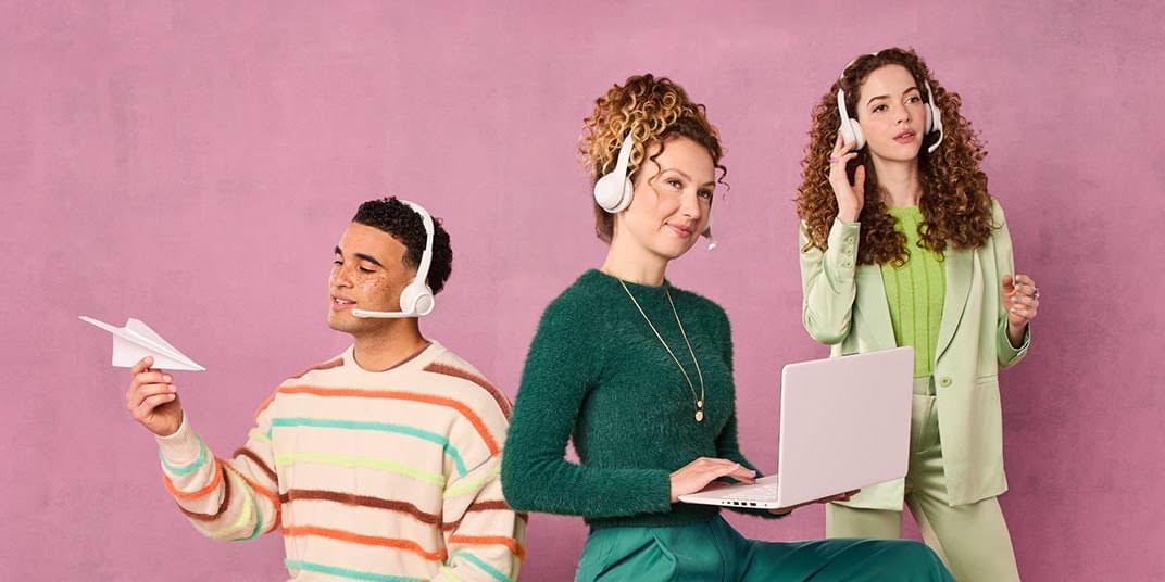 Three people with headsets are talking to customers while standing, holding a laptop, and looking at a paper airplane.