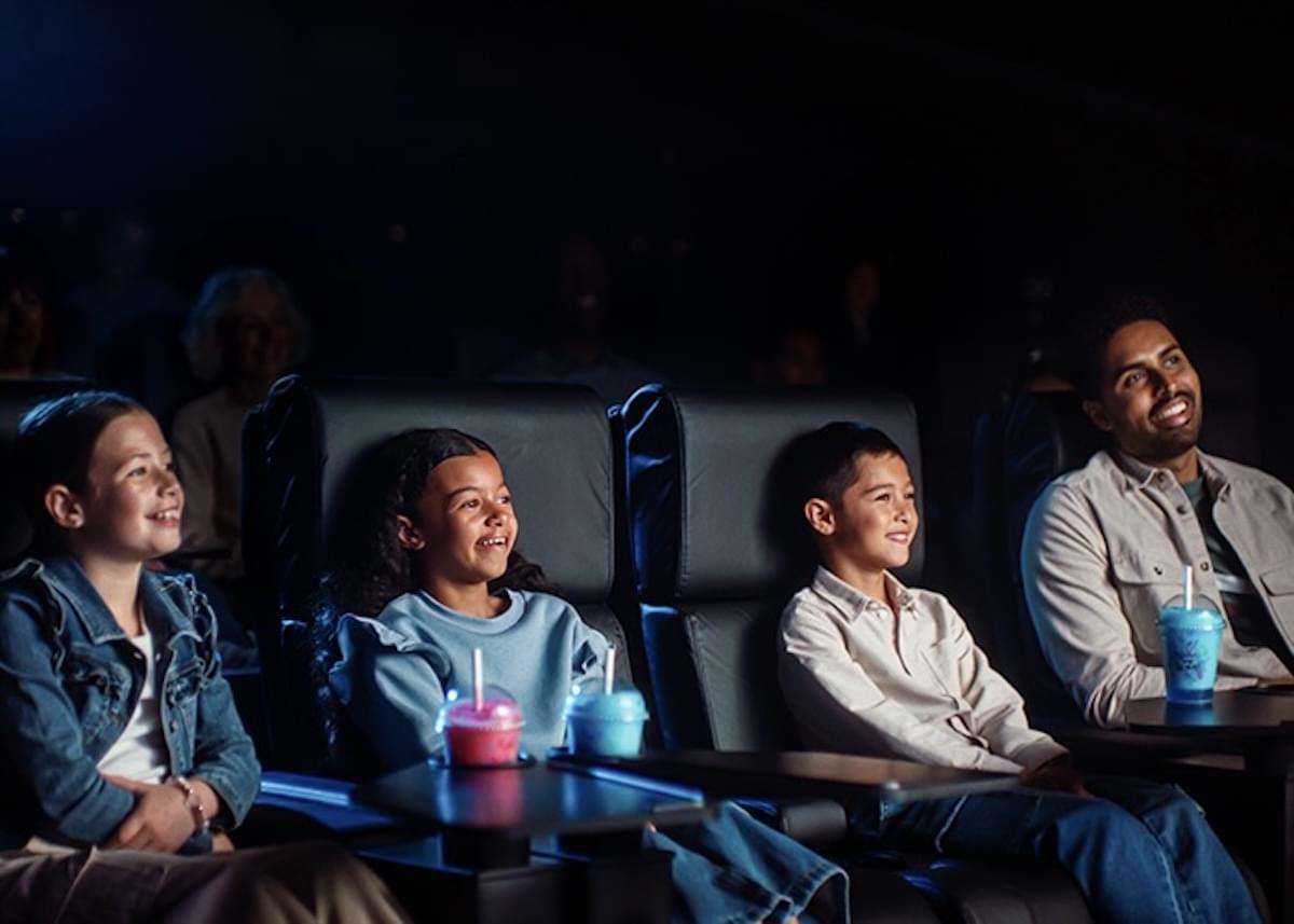 Moviegoers sit inside and watch a movie inside a darkened ODEON Cinema