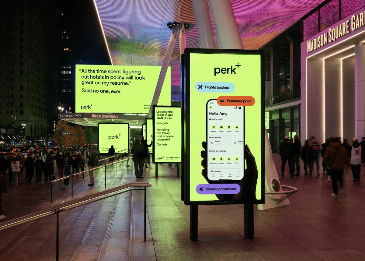 Several bright lime green Perk digital ads outside Madison Square Garden in New York City at night