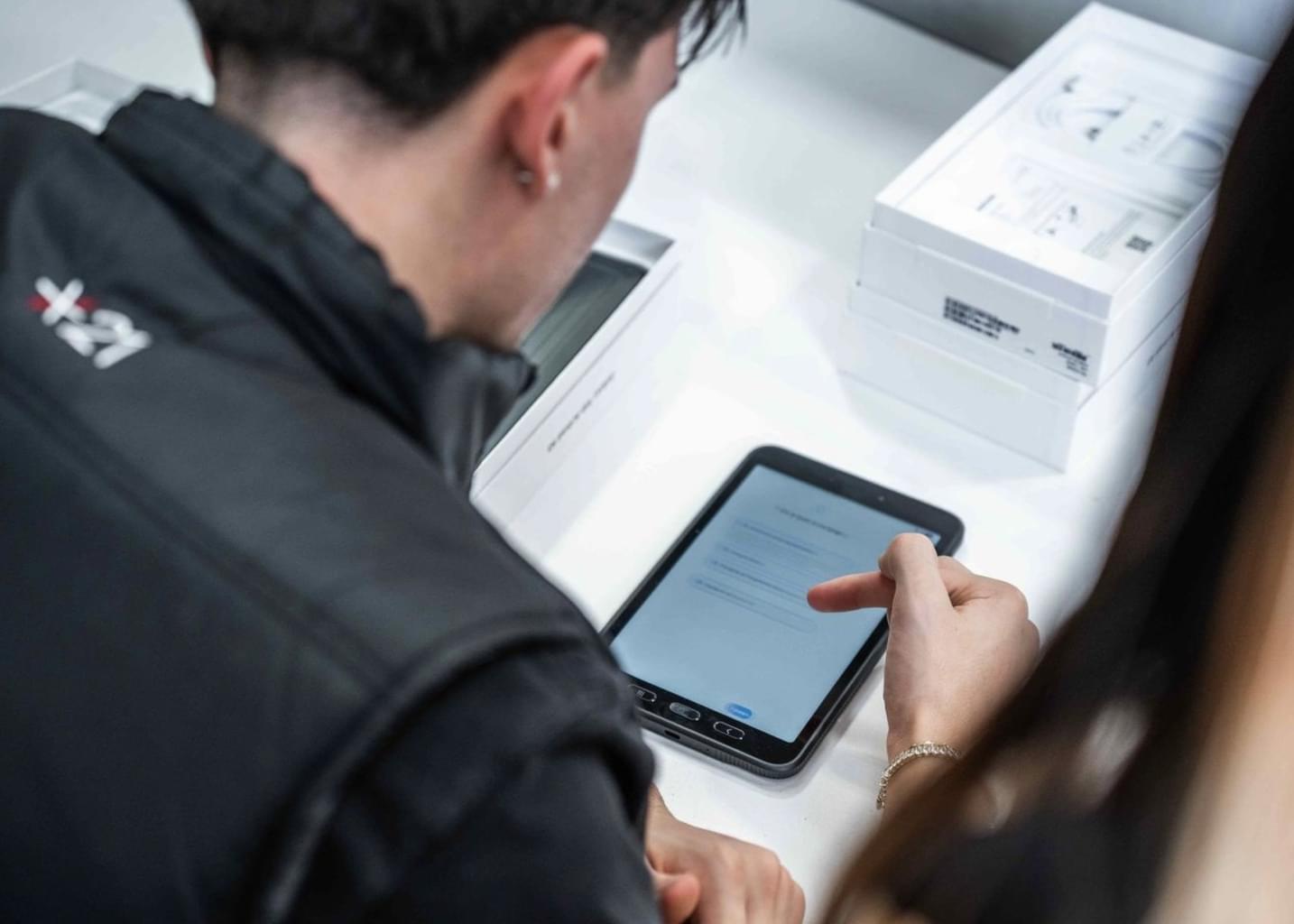 A Star21 employee scrolls through a tablet