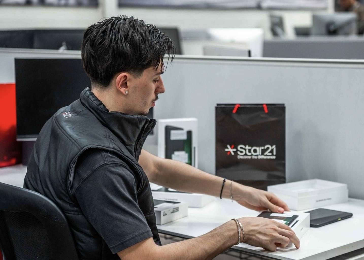A Star21 employee unboxes a new mobile phone