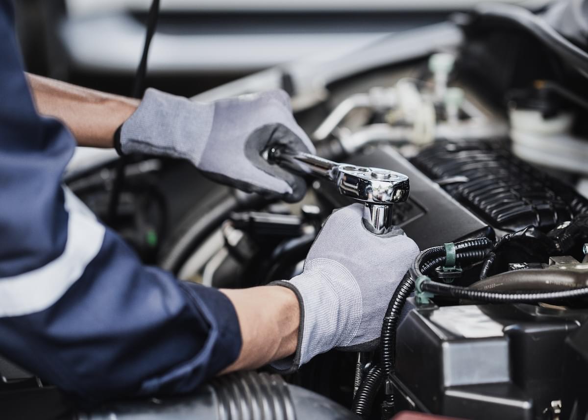 Professional mechanic working on the engine of the car in the garage
