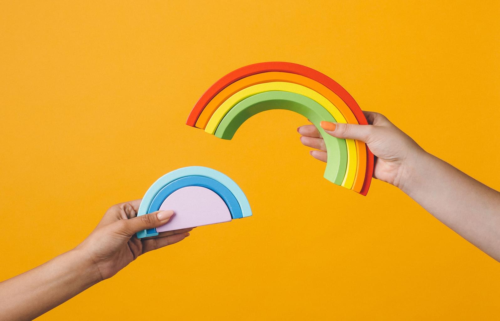 image of hands and rainbows on bright background