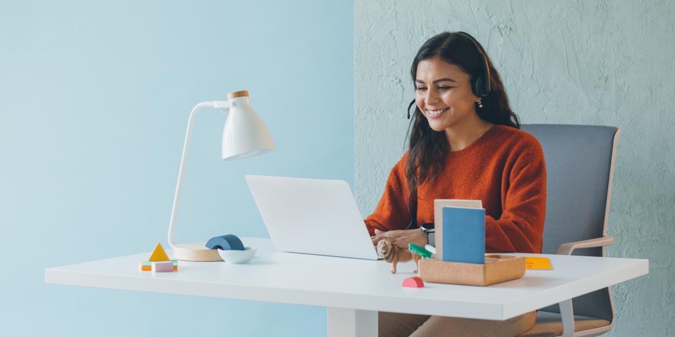 Smiling woman at a desk with laptop