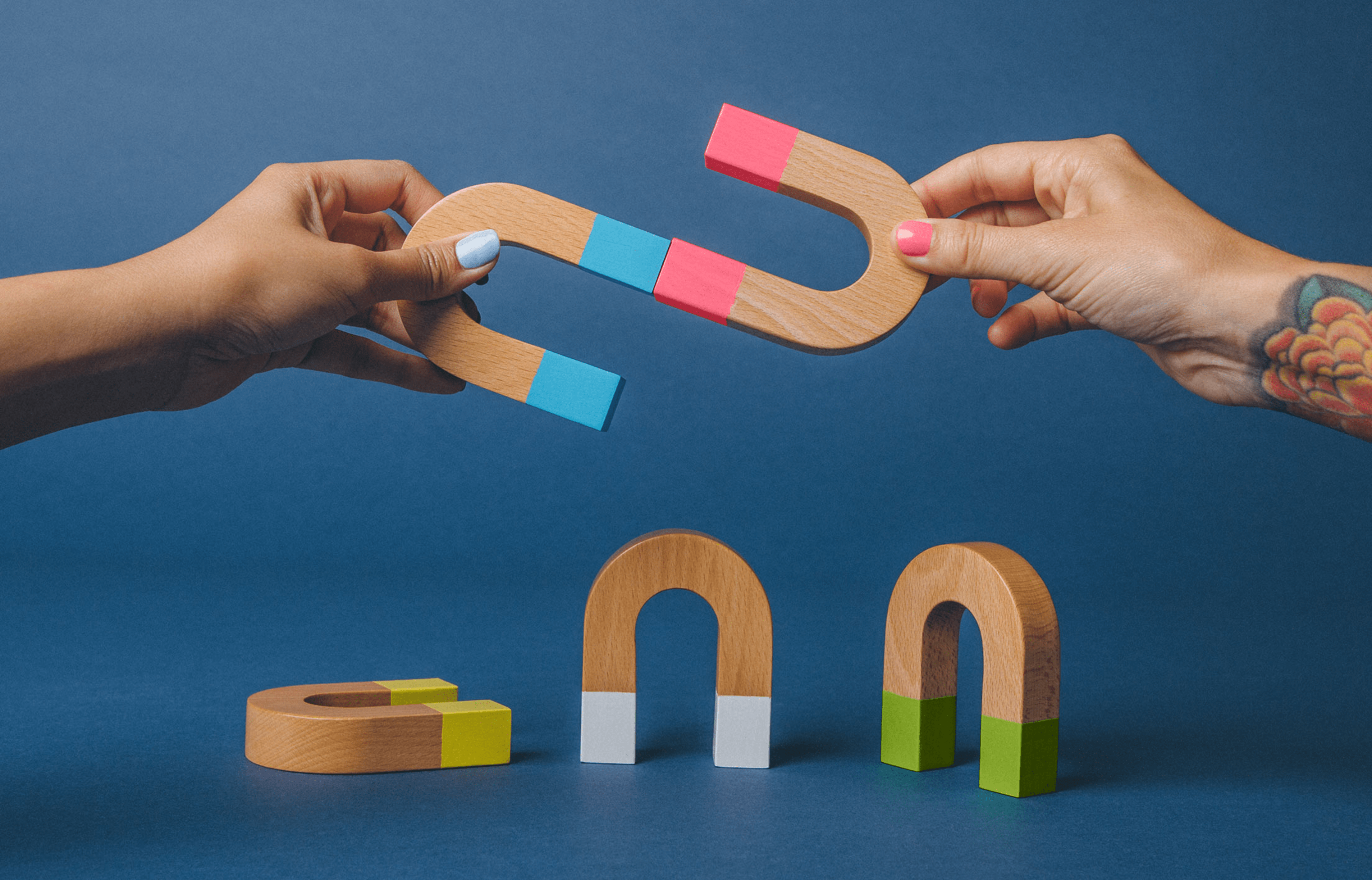 People holding U-shaped blocks joining them together while other blocks are on a surface around them