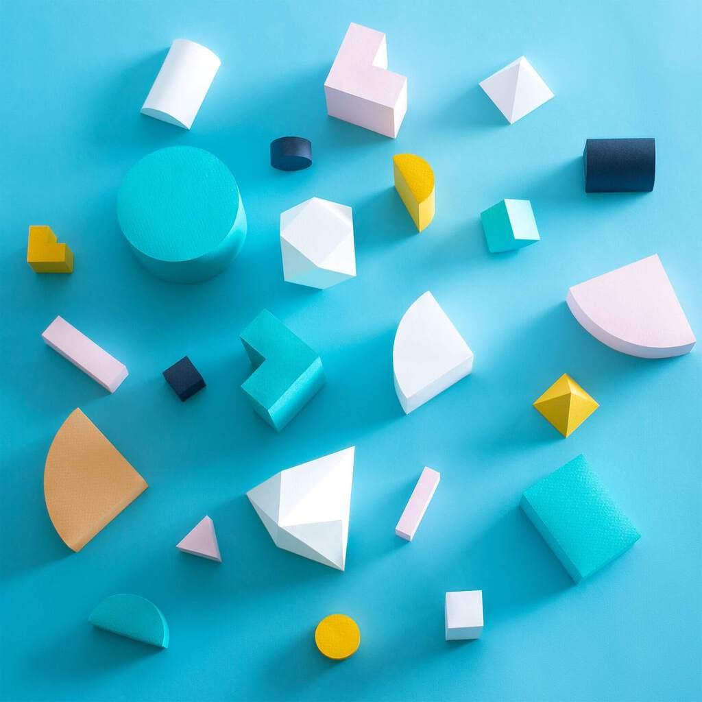 Wooden blocks of various shapes and colored arranged in a haphazard fashion